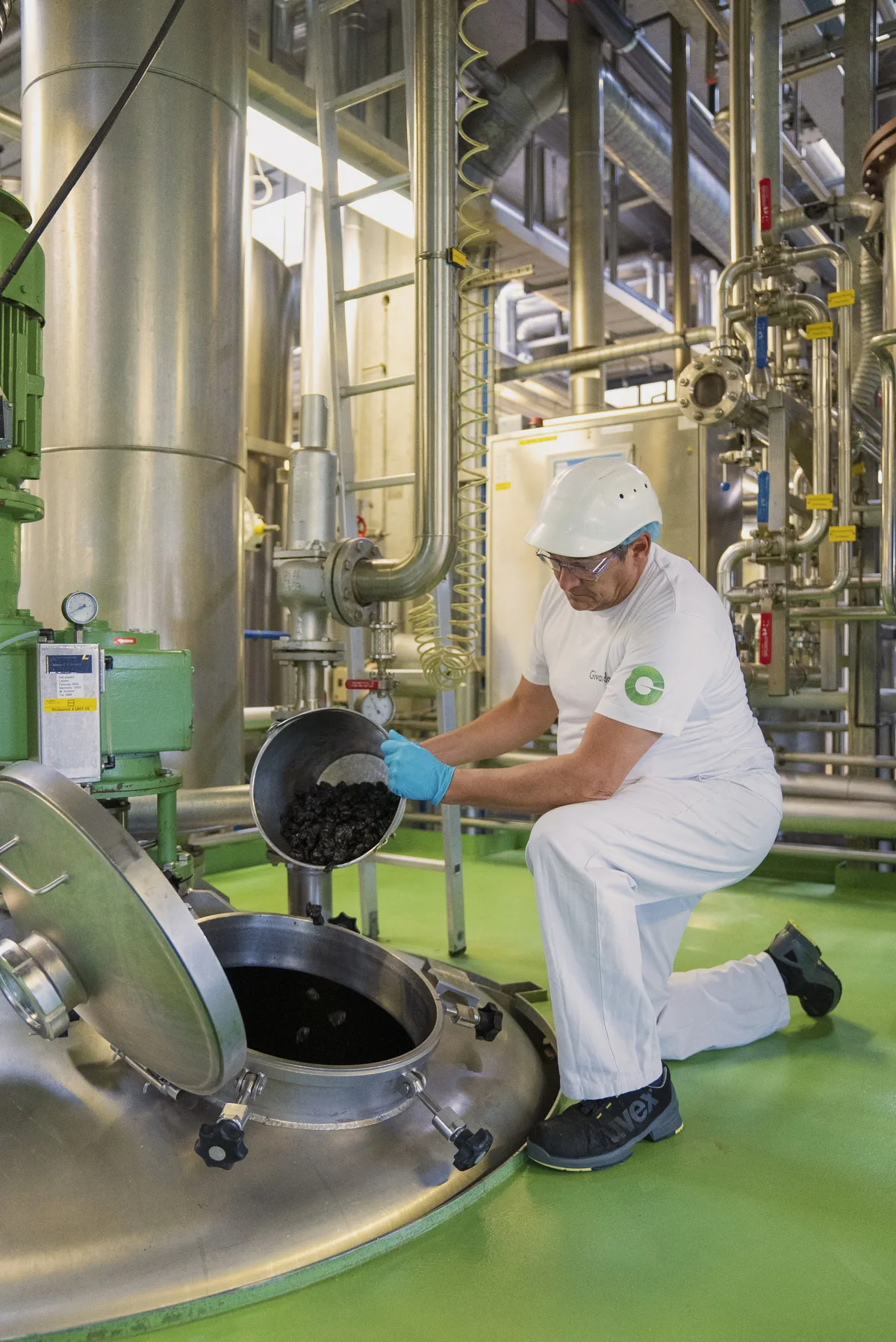 Aus den natürlichen Rohstoffen extrahiert Givaudan Aromen. Ein Mitarbeiter schüttet einen Rohstoff in einen grossen Behälter.